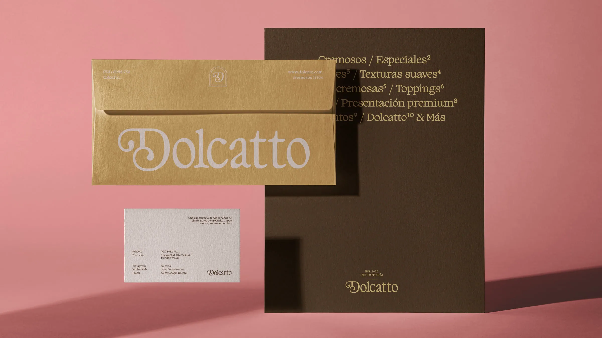 Papelería sobre fondo rosa: sobre dorado con el logotipo Dolcatto, tarjeta blanca y carpeta marrón con la lista de productos